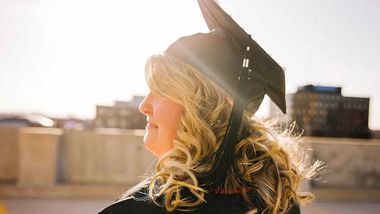 College graduate standing in sunlight