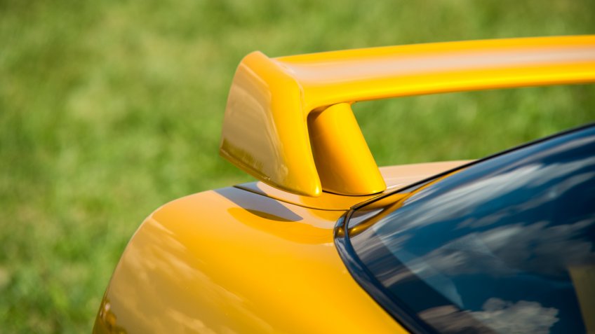 Closeup detail of a custom racing spoiler on the rear of a sports car.