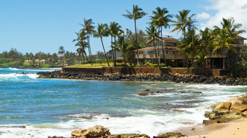 "House surrounded by tall palm trees facing the beautiful blue ocean and a sandy beach at south shore of Kauai, Hawaii on a gorgeous sunny, summer day in the tropicsCheck out my Hawaiian Lightbox with more images:".