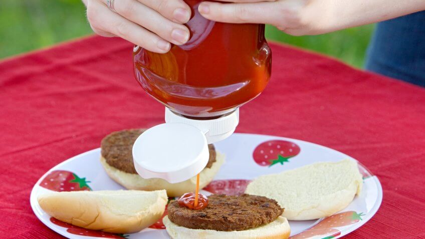 Close-up of Person Putting Ketchup on Hamburger