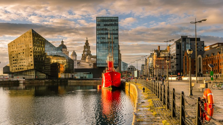 Liverpool's historic waterfront with modern and old architecture at sunset.