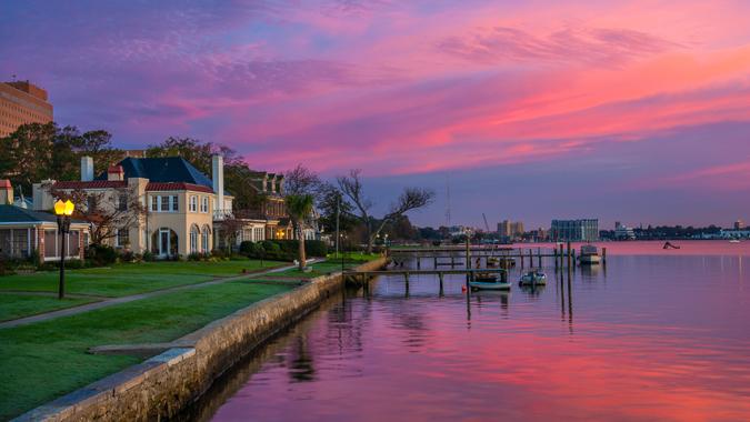 Houses and Riverfront of the Elizabeth River in Portsmouth, Virginia during dawn with magenta, purple, and pink clouds.