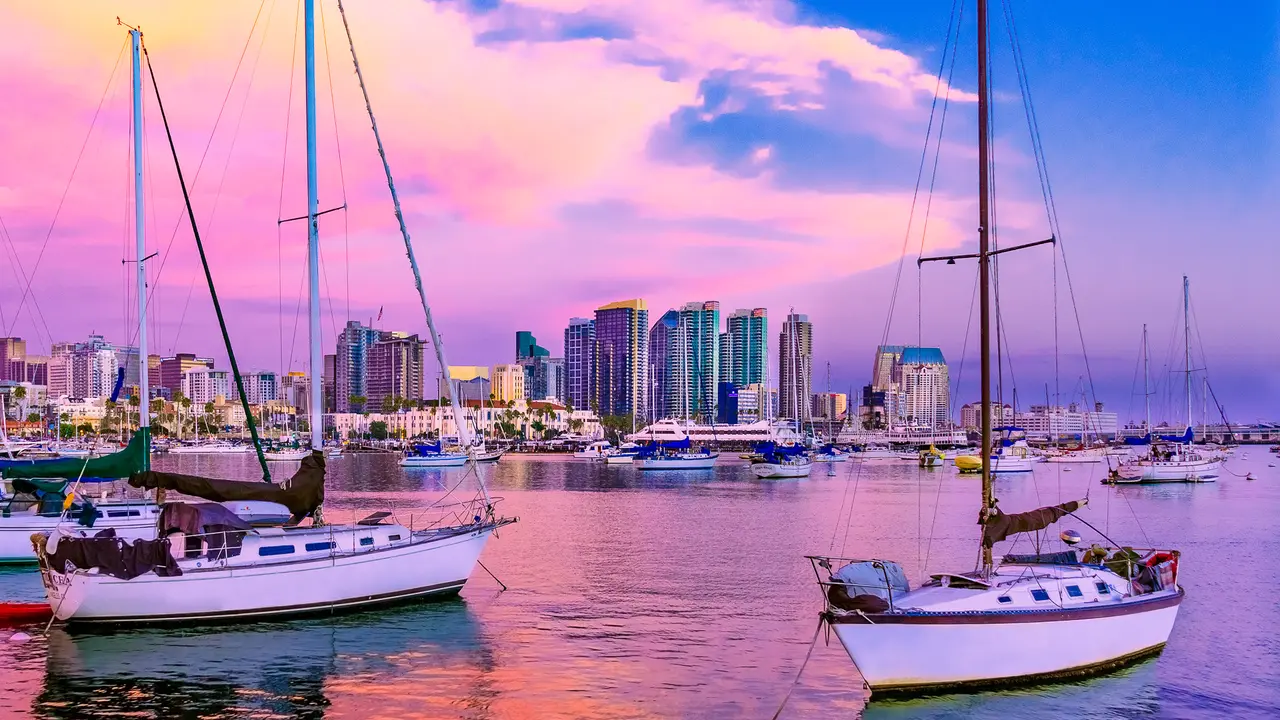 Recreational boats on San Diego Bay fill the foreground leading back to the skyscrapers of San Diego Skyline waterfront and harbor at dusk, CA.