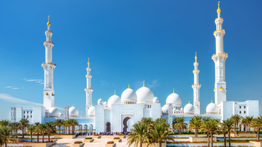 The Sheikh Zayed Grand Mosque Abu Dhabi (UAE) on a beautiful November day with large groups of unrecognizable tourists.