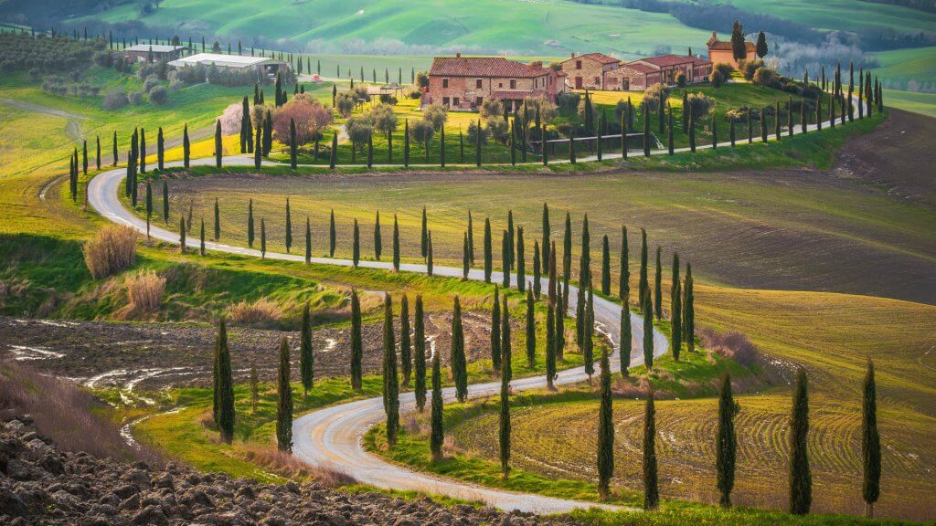 Sunny fields and winding road in Tuscany, Italy
