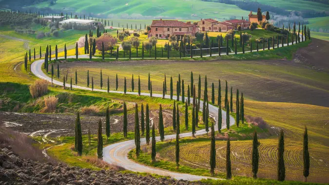 Sunny fields and winding road in Tuscany, Italy