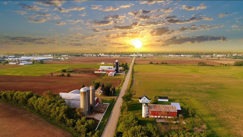 Idyllic rural agricultural landscape with dramatic sky at dawn.