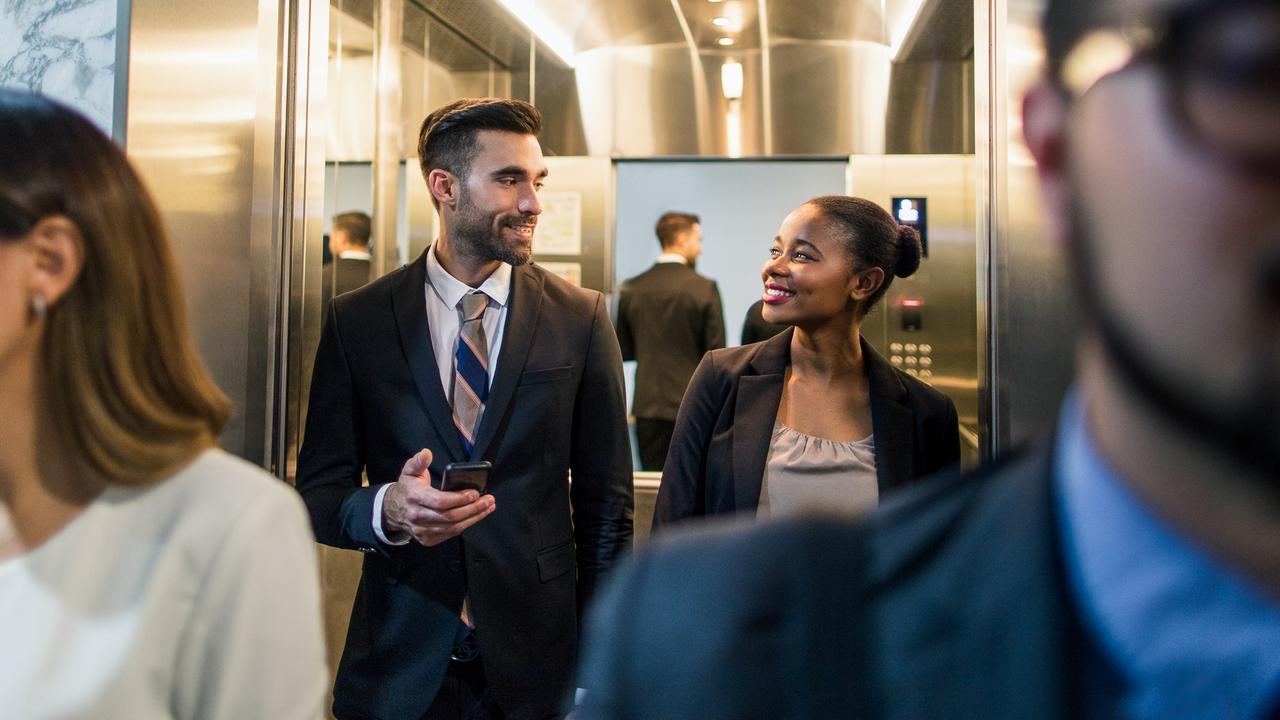businessman talking with coworker in elevator