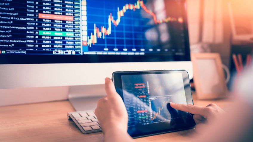female using tablet looking at stock market chart