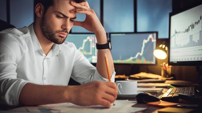 frustrated man with trading charts in background