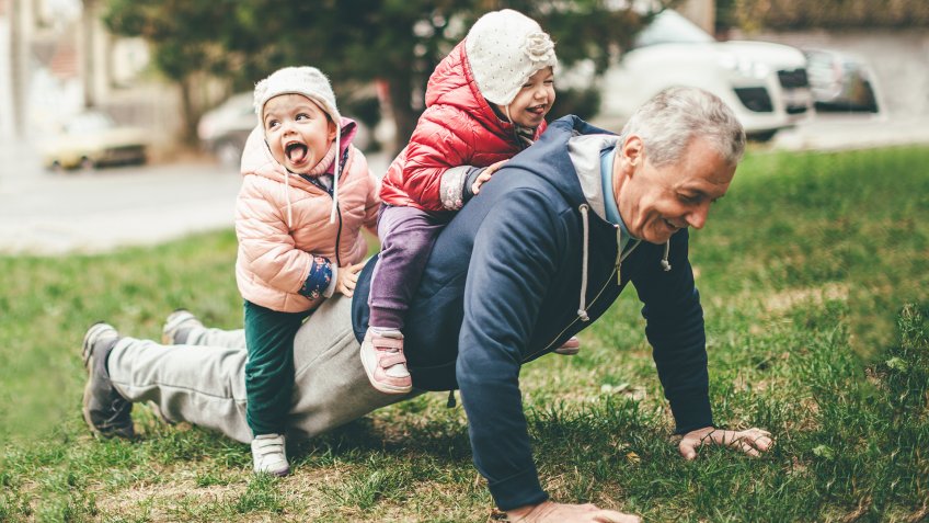 A photo of a playful grandfather and granddaughter.
