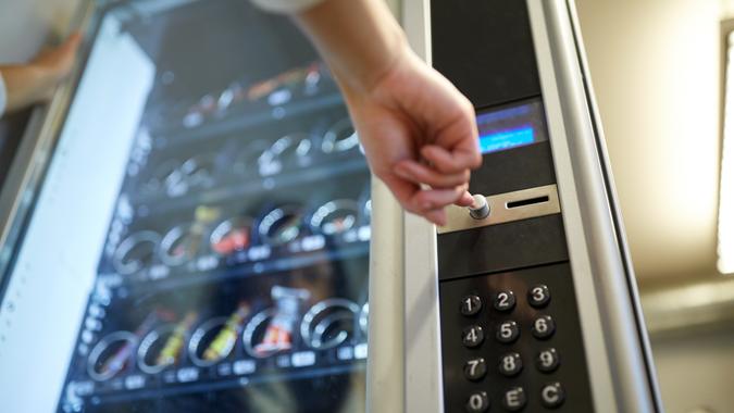 hand pushing button on vending machine