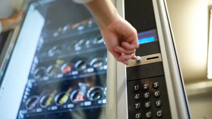 hand pushing button on vending machine