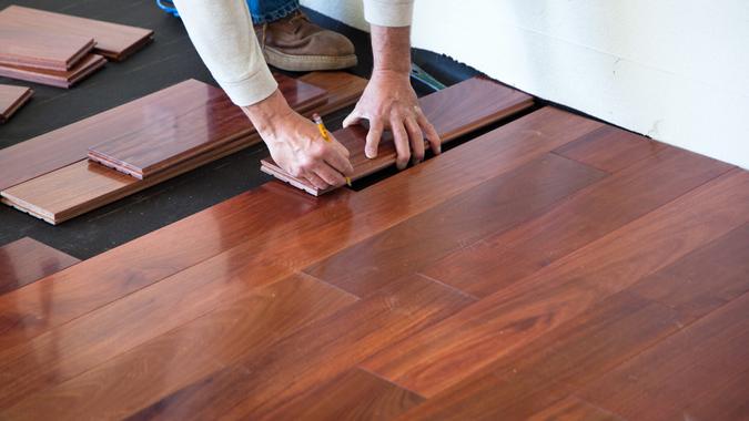 A worker installing hardwood floor in an American upscale home.