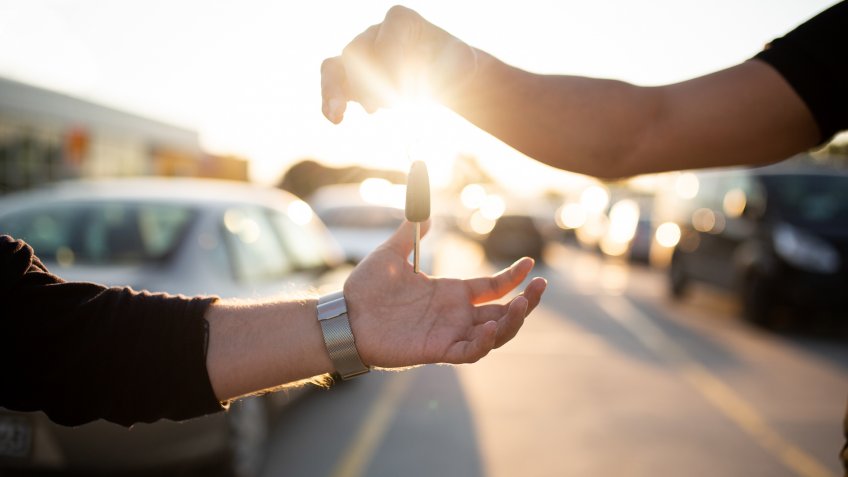 man receiving keys to his new car