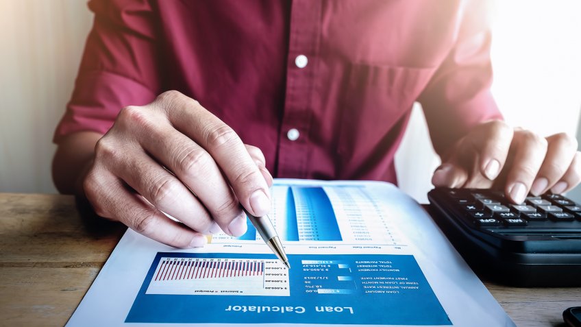 man using loan calculator for buying a used home