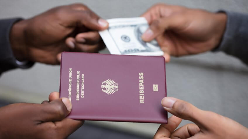 person handing over counterfeit passport for money