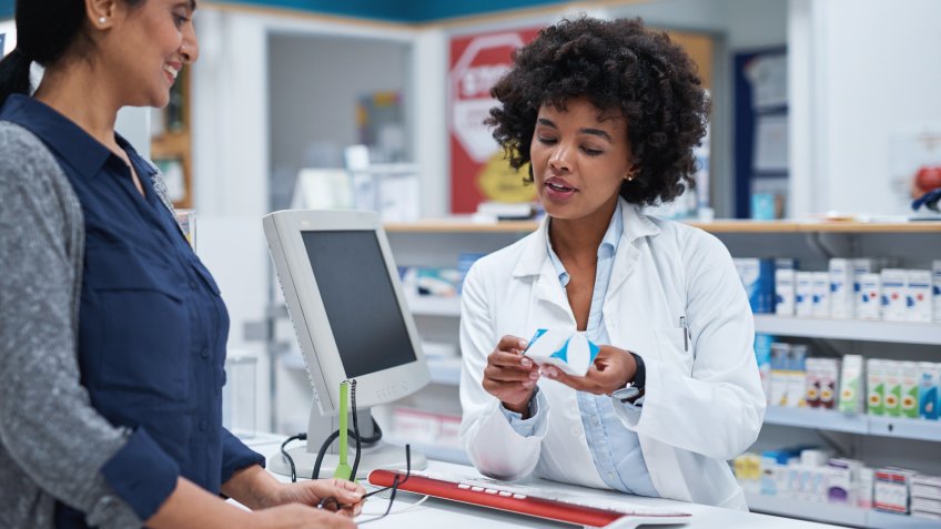 Shot of a pharmacist assisting a customer in a chemist.