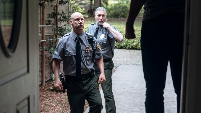 Two law enforcement officers, working hard at providing justice, keeping the peace, and making the country a safer place, try to talk down a man in his home holding a baseball bat.