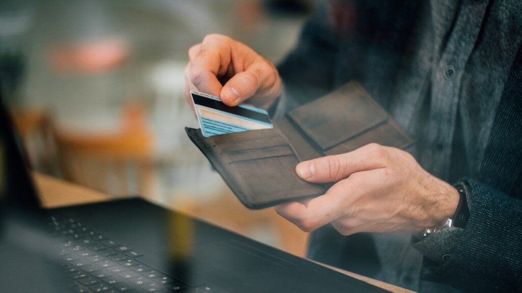 Man taking out credit card from a wallet.