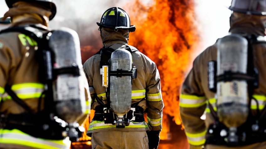 Three firefighters putting out an house fire.