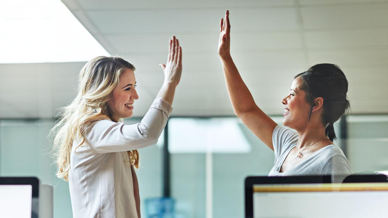 Shot of two colleagues giving each other a high five at work.