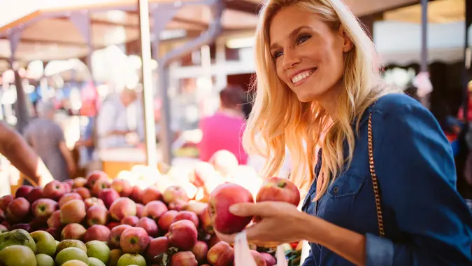 Mid adult woman buying fruits on greenmarket.