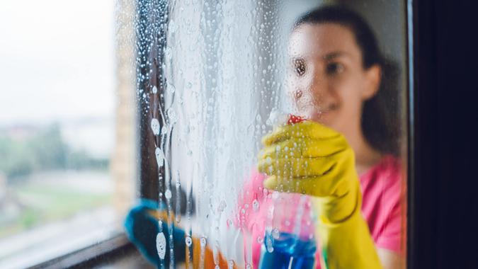 Young woman washing window Young woman wiping windows at home.