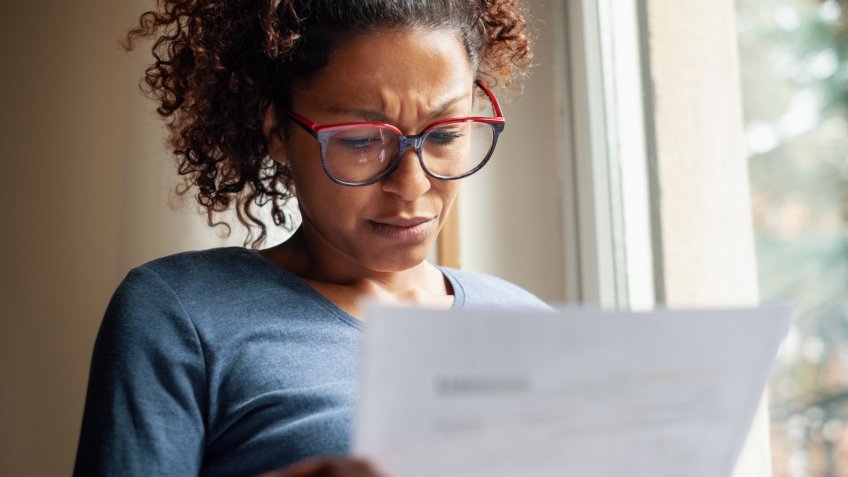 Portrait of worried black woman standing beside window.