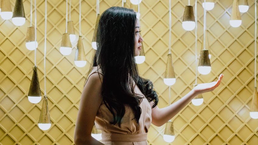woman standing in room with light bulbs
