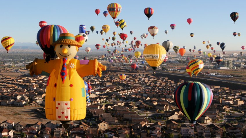 Albuquerque, New Mexico, USA - October 11, 2006: The scarecrow special shape hot air balloon ascends at dawn with hundreds of other balloons above Albuquerque at the Albuquerque International Balloon Fiesta - the largest such festival in the world.
