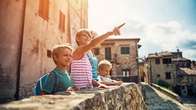 Mother and kids tourists sightseeing beautiful Italian town.