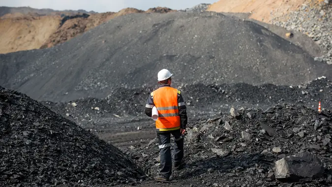 Coal mining in an open pit - Worker is looking on the huge open pit.