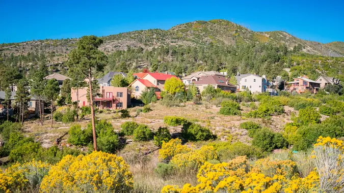 Photo of a residential neighborhood with large houses in Los Alamos, New Mexico, USA, on a clear blue sky day.