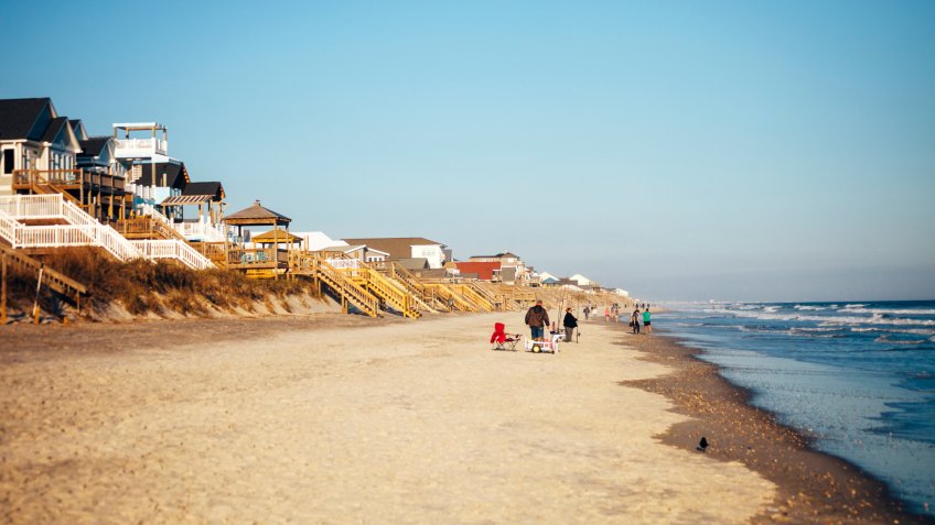 Surf City, North Carolina, USA - December 25, 2016: People enjoying warm winter sunset at the beach.