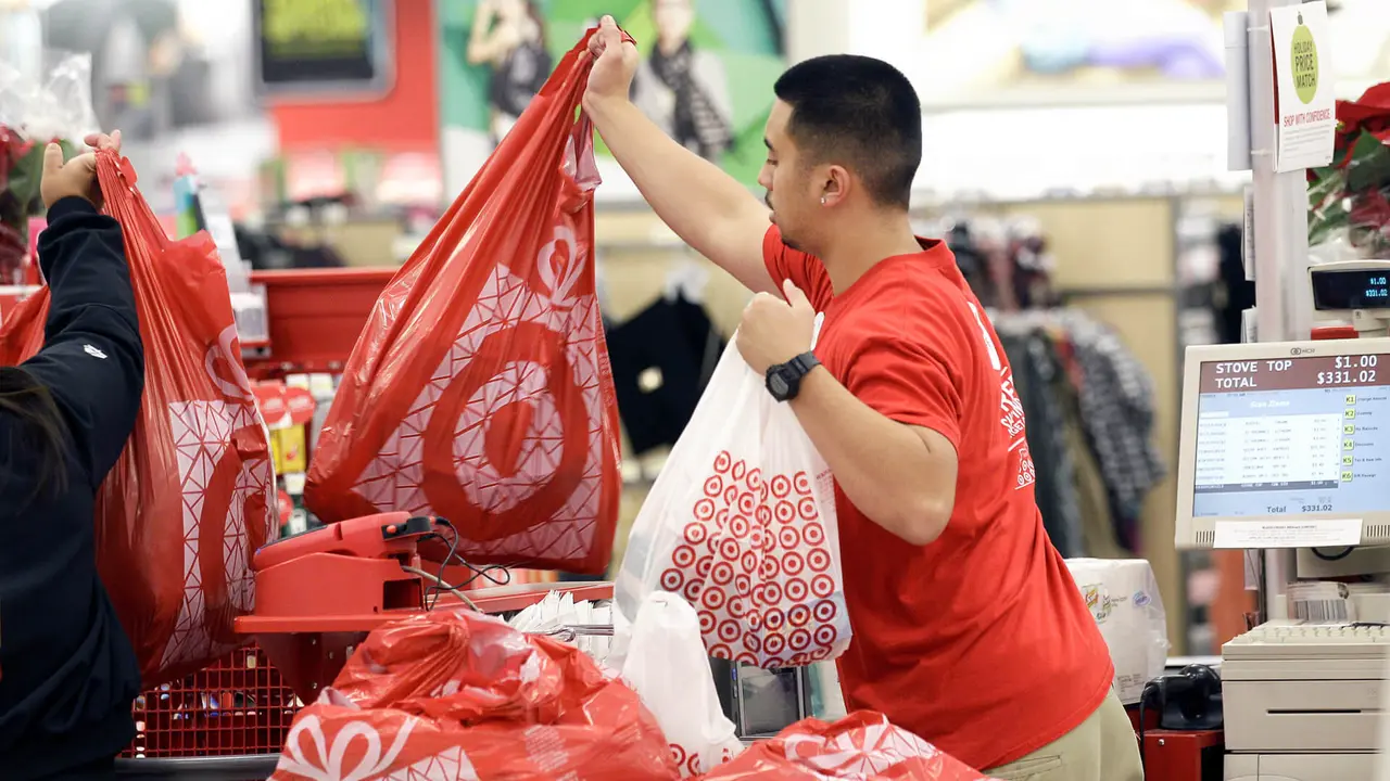 Photo by Jeff Chiu/AP/REX/Shutterstock Target A Target employee hands bags to a customer at the register at a Target store in Colma, Calif. Target executives on said the company is handing out free Fitbit activity trackers to its more than 300,000 employees as the retailer tries to portray itself as a healthier place for both customers and workers Target Wellness, Colma, USA