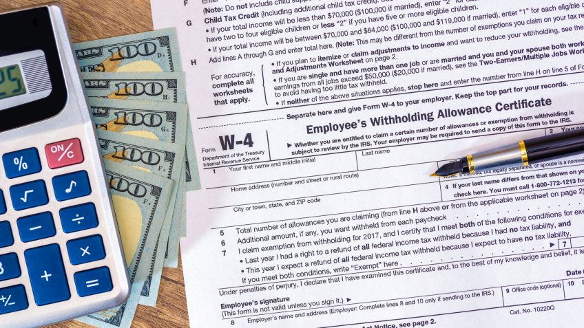 w4 tax form with money and pen.