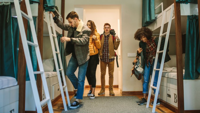 Young travelers in hostel bedroom.
