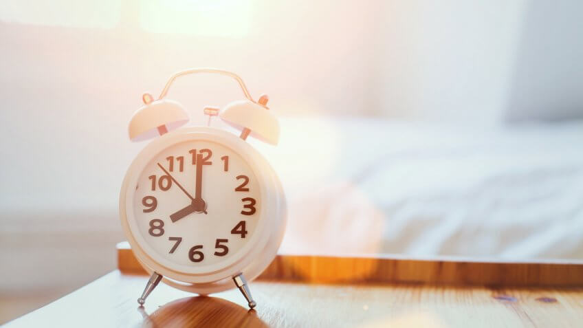 morning time background, alarm clock near the bed at home.