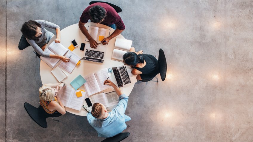 Top view of group of students sitting together at table.
