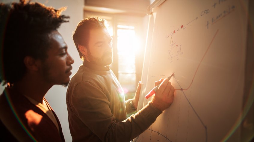 Mid adult businessman and his African American colleague analyzing a chart in the office.