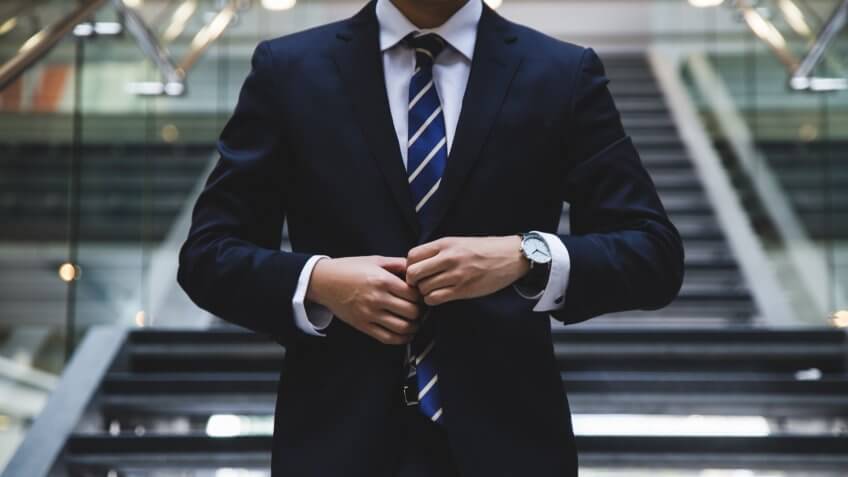 businessman buttoning up his suit jacket