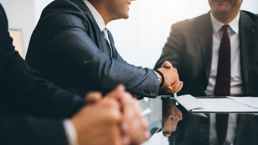 Business people shaking hands, finishing up a deal.