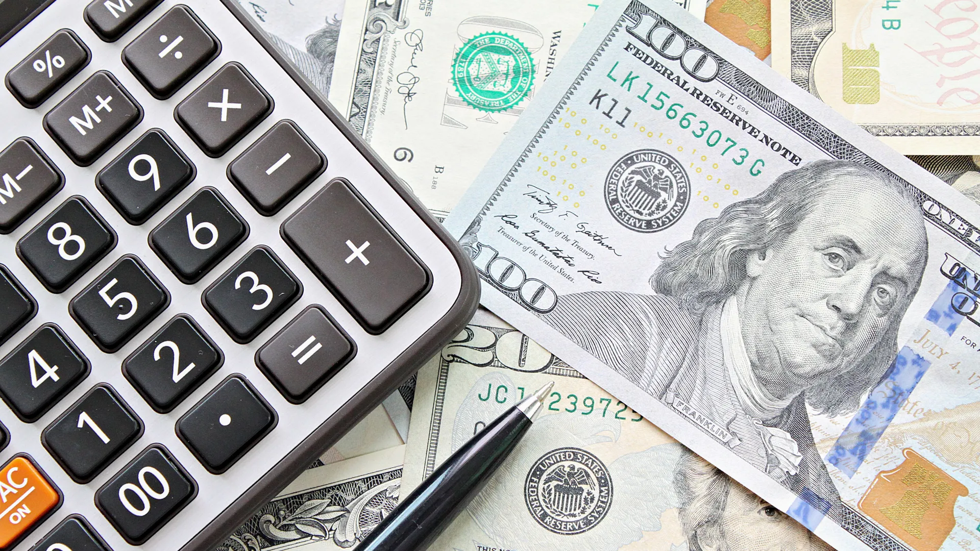 Business, finance, investment, accounting, taxes or money exchange concept : Top view or flat lay of calculator and pen on American Dollars cash money.