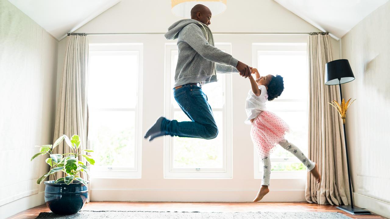Side view of father and daughter jumping while performing ballet.