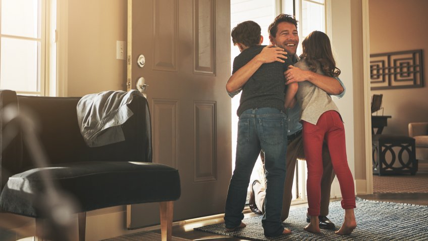 Shot of a father arriving home to a loving welcome from his son and daughter.