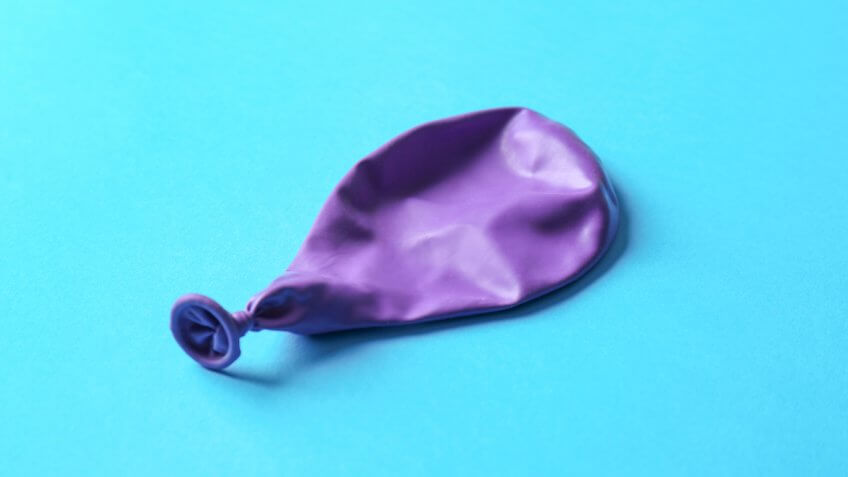 deflated purple balloon on blue background