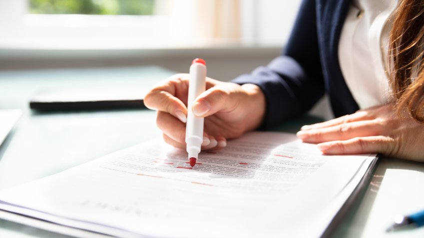 Businesswoman's Hand Marking Error In Contract Form With Marker.