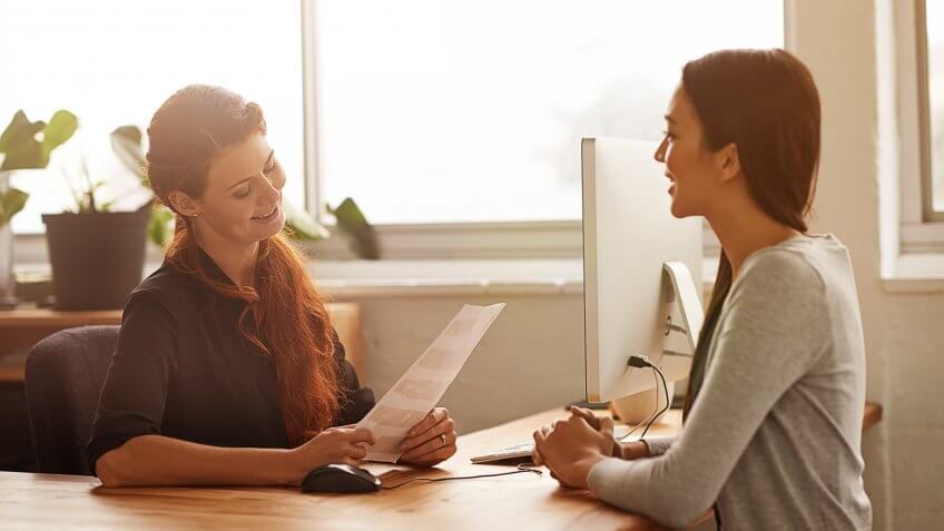 Shot of two young businesswomen having a discussion at a desk.