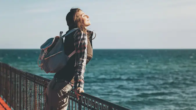 Young woman with eyes closed enjoying the air and sea on a sunny day.
